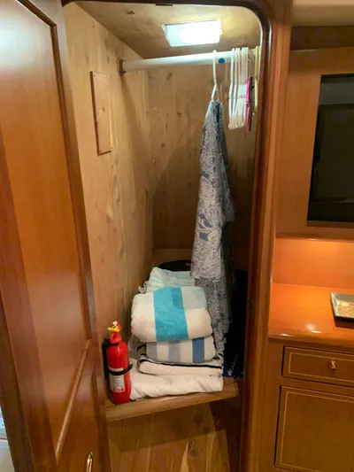  Yacht Photos Pics Wooden closet interior on 2004 Ocean Yachts 57 Odyssey, with clothes and fire extinguisher.