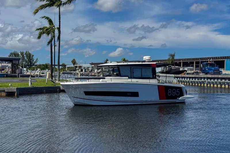  Yacht Photos Pics 2018 Jeanneau NC 895 boat docked in a marina under a clear blue sky.