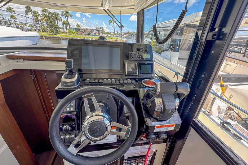  Yacht Photos Pics 2018 Jeanneau NC 895 helm with steering wheel, navigation controls, and display screens.