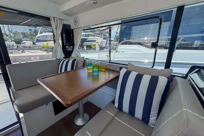  Yacht Photos Pics Interior of 2018 Jeanneau NC 895 boat with dining area and striped cushions.