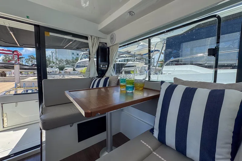  Yacht Photos Pics Interior of 2018 Jeanneau NC 895 boat with cozy seating and striped cushions.