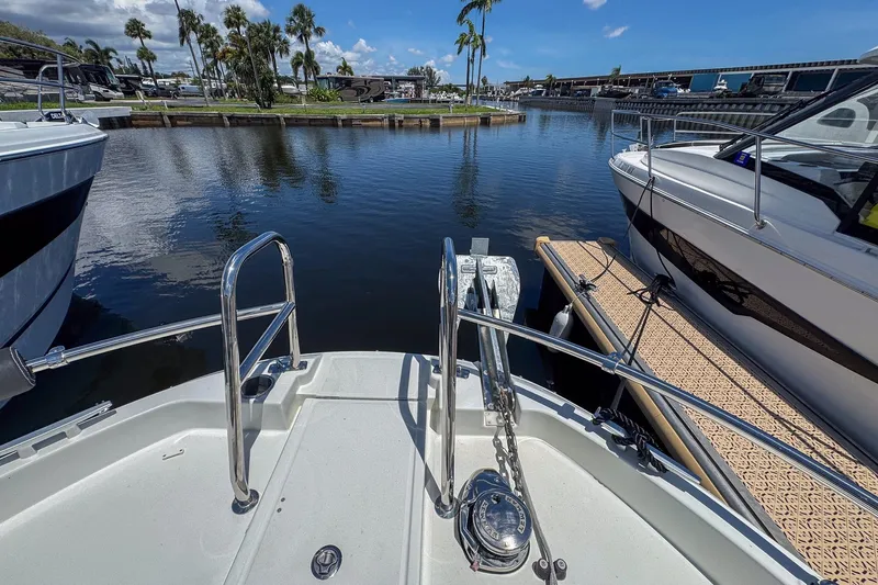  Yacht Photos Pics Bow view of 2018 Jeanneau NC 895 docked in a marina with palm trees.
