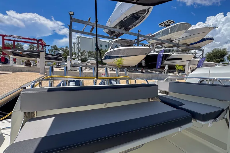  Yacht Photos Pics 2018 Jeanneau NC 895 boat in marina, surrounded by other docked vessels under a clear blue sky.