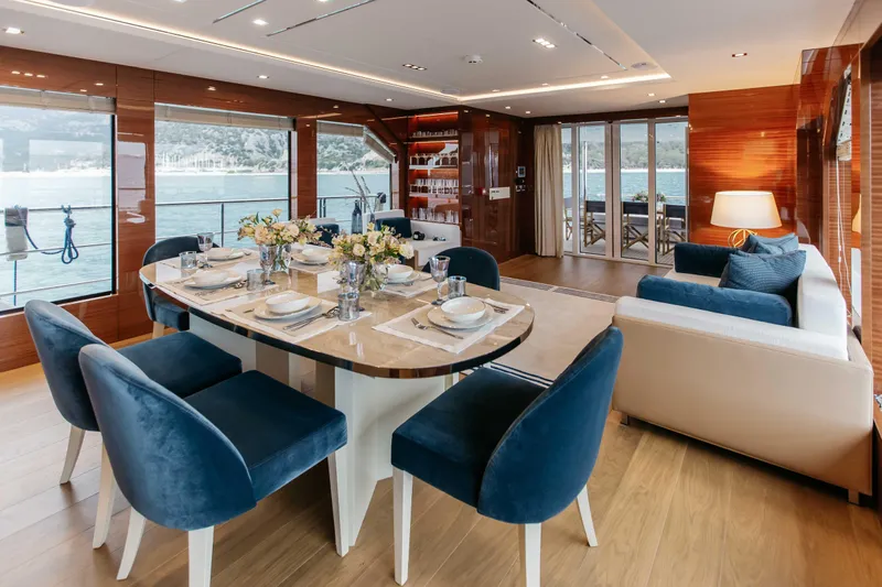 Papillon Yacht Photos Pics Luxurious interior of 2022 Bering 92 yacht with elegant dining area and scenic ocean views.