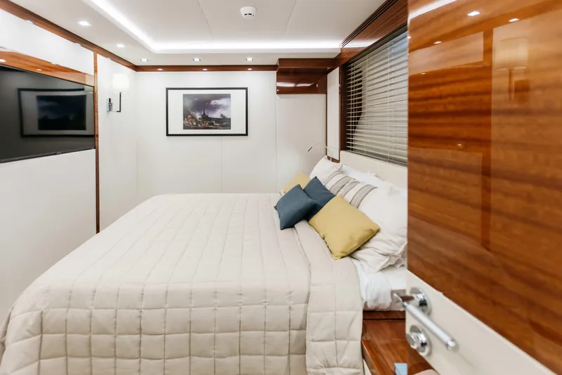 Papillon Yacht Photos Pics Luxurious bedroom interior on 2022 Bering 92 yacht, featuring elegant wood finishes and cozy bedding.
