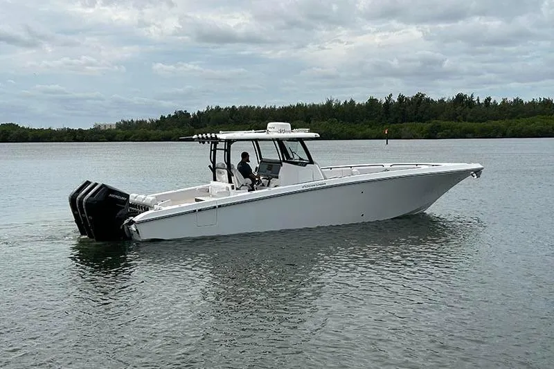  Yacht Photos Pics 2025 Fountain 38 Center Console boat on calm water, featuring triple outboard engines.