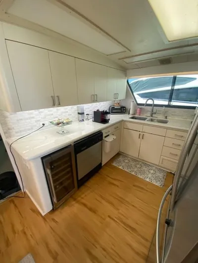  Yacht Photos Pics 1989 Hatteras Custom Cockpit kitchen with modern appliances, white cabinetry, and wood flooring.