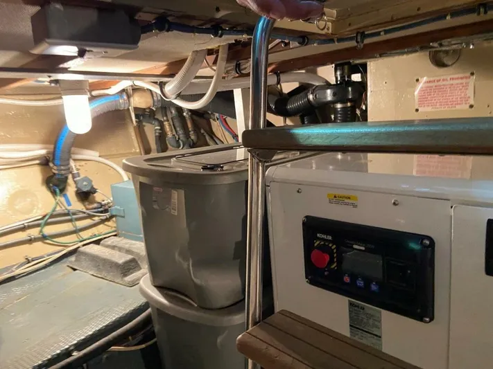  Yacht Photos Pics Engine room of 1989 Hatteras Custom Cockpit boat with equipment and storage containers.