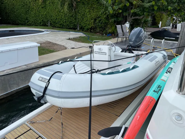 Fina Yacht Photos Pics Inflatable boat docked beside a Fountaine Pajot MY 44, 2020 model, with lush greenery background.