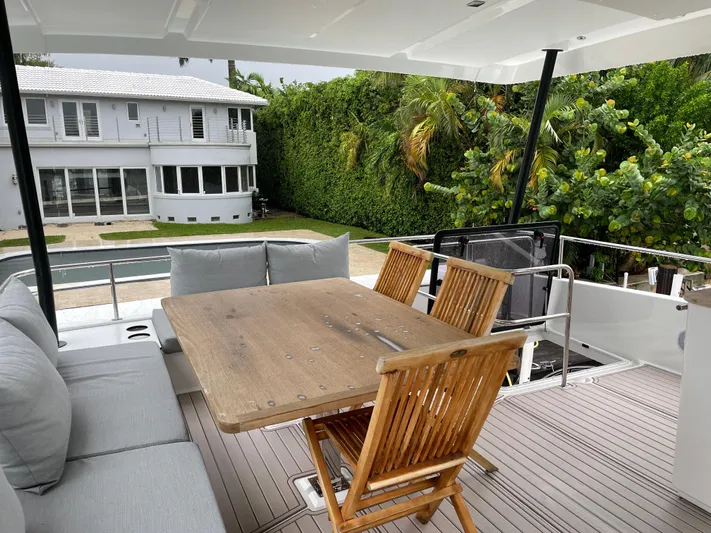 Fina Yacht Photos Pics Outdoor seating area on a 2020 Fountaine Pajot MY 44 yacht, near a modern house.