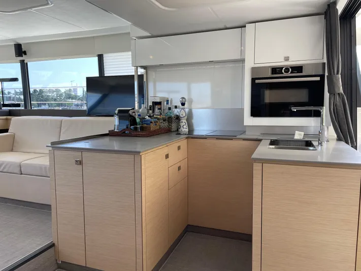 Fina Yacht Photos Pics Modern kitchen interior on 2020 Fountaine Pajot MY 44 yacht, featuring sleek cabinetry and appliances.