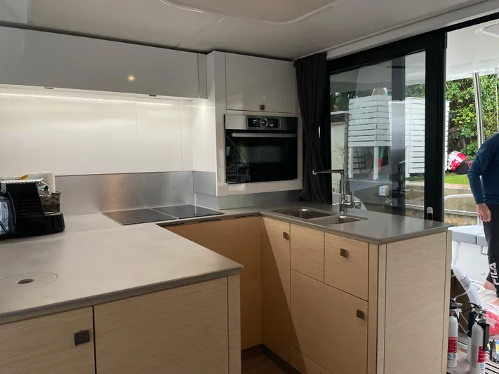Fina Yacht Photos Pics Modern kitchen interior on 2020 Fountaine Pajot MY 44 yacht, featuring sleek cabinetry and appliances.