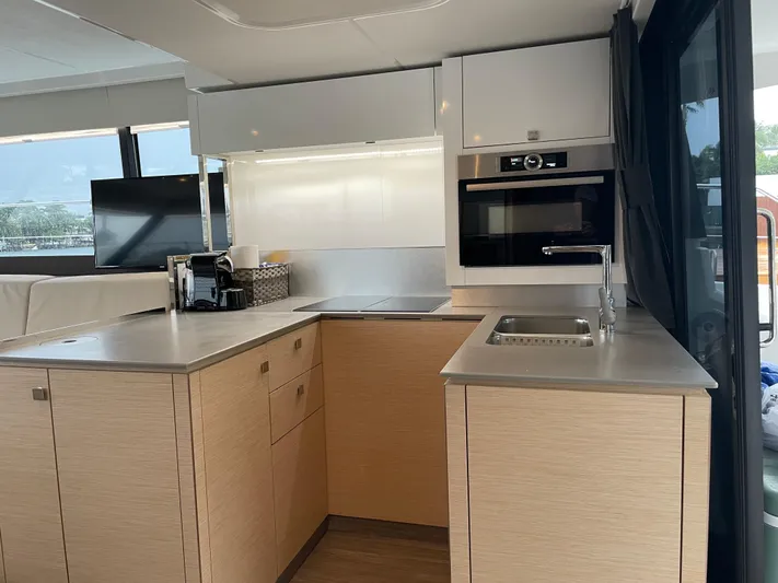 Fina Yacht Photos Pics Modern kitchen interior on 2020 Fountaine Pajot MY 44 yacht, featuring sleek cabinetry and appliances.