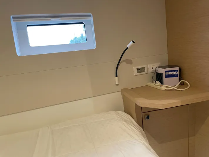 Fina Yacht Photos Pics Cozy cabin interior of 2020 Fountaine Pajot MY 44 yacht with window and bedside lamp.