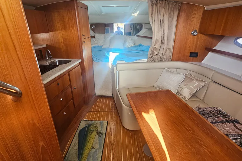 Deep Rapture Yacht Photos Pics 2003 Tiara Yachts 3100 Open LE interior with wood finish, seating, and kitchenette.