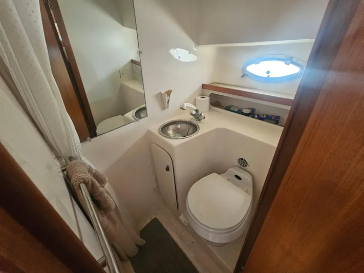 Deep Rapture Yacht Photos Pics 2003 Tiara Yachts 3100 Open LE bathroom with sink, toilet, and porthole window.