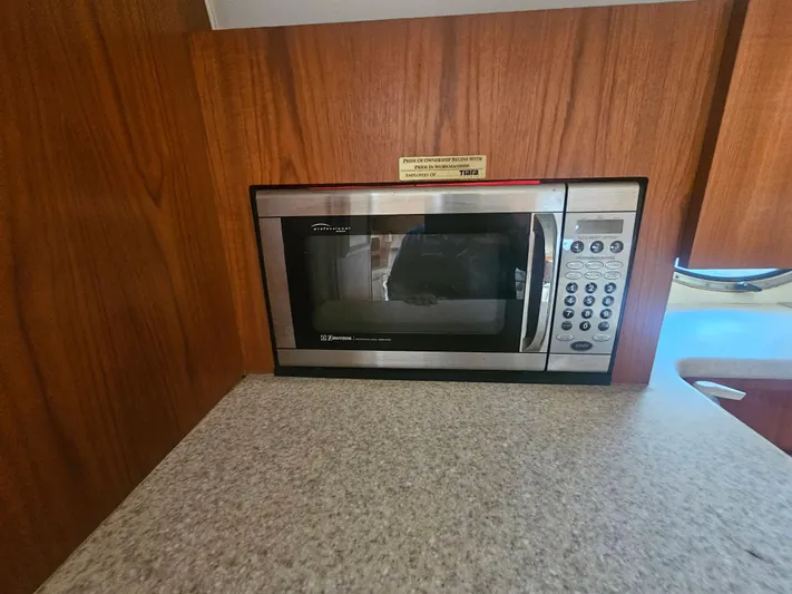 Deep Rapture Yacht Photos Pics Built-in microwave in 2003 Tiara Yachts 3100 Open LE galley, with wood paneling and countertop.