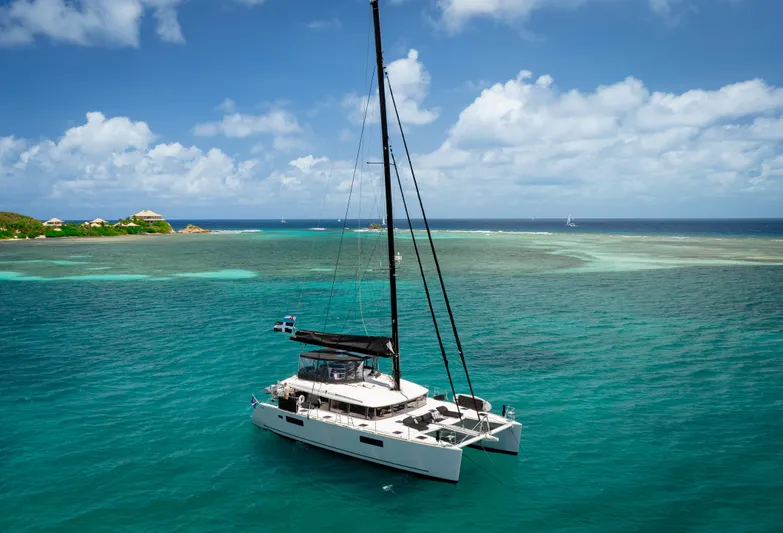 Respite At Sea Yacht Photos Pics 2018 Lagoon 560 catamaran sailing in clear turquoise waters under a blue sky.