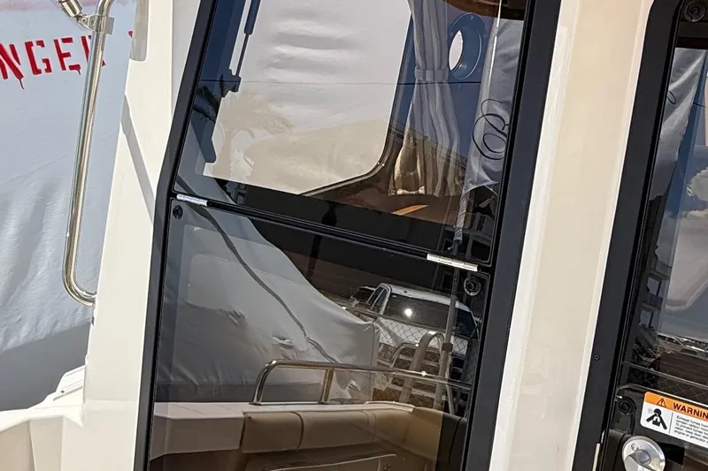  Yacht Photos Pics 2025 Ranger Tugs R-23 boat door with reflective glass and stainless steel handle.