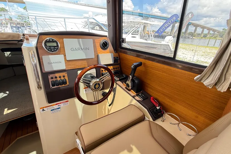  Yacht Photos Pics 2025 Ranger Tugs R-23 helm with Garmin navigation, wood accents, and comfortable seating.