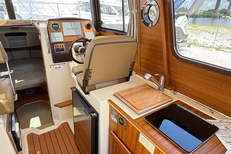  Yacht Photos Pics Interior of 2025 Ranger Tugs R-23 boat with helm, sink, and seating area.