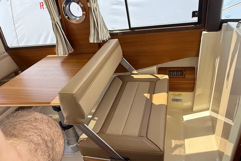  Yacht Photos Pics Interior of 2025 Ranger Tugs R-23, featuring a wooden table and beige seating.