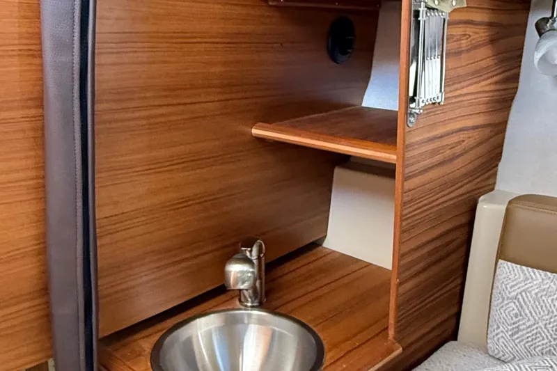  Yacht Photos Pics 2025 Ranger Tugs R-23 interior with wooden cabinetry and stainless steel sink.