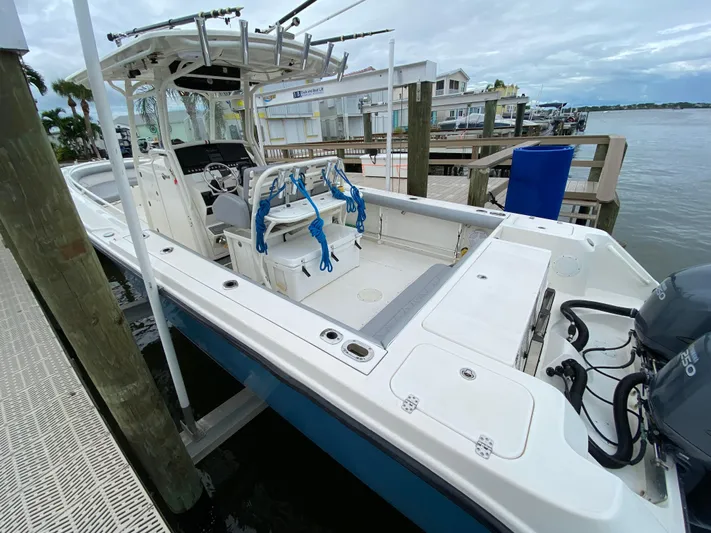  Yacht Photos Pics 2007 Edgewater 318CC boat docked by waterfront homes, featuring spacious deck and fishing equipment.