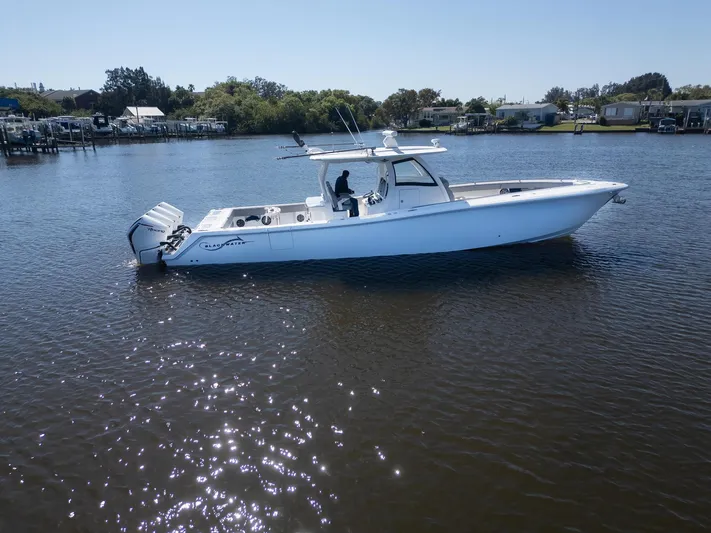 Grey Goose Yacht Photos Pics 2020 Blackwater 43 Sportfish boat on calm water, side view, sunny day.