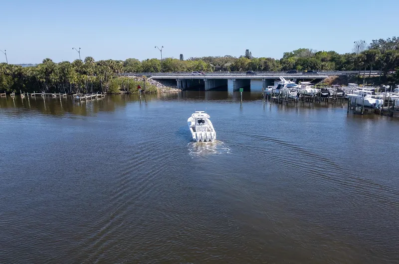 Grey Goose Yacht Photos Pics 2020 Blackwater 43 Sportfish boat cruising on a calm river near a bridge.