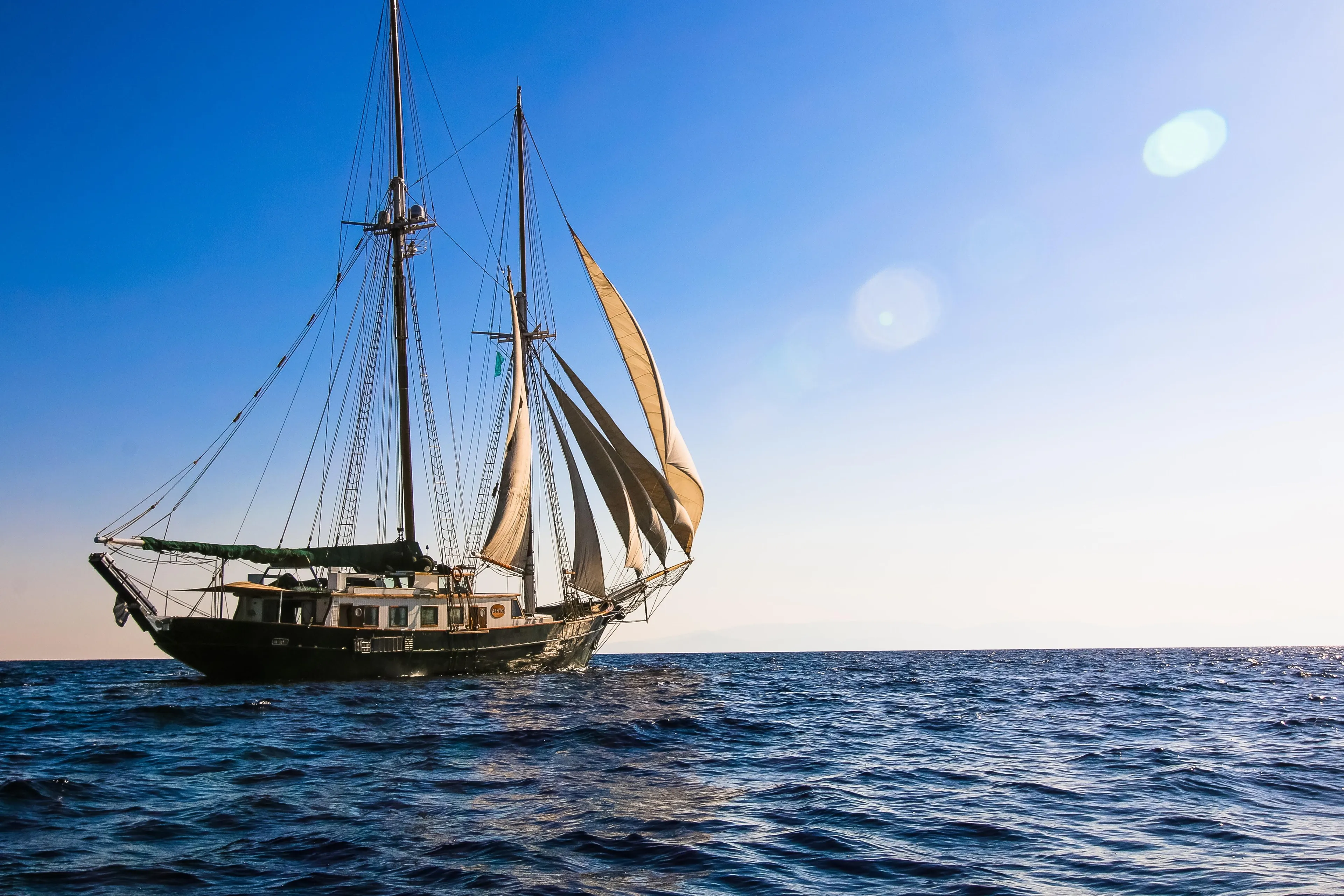 Sailing ship on open sea under clear blue sky, 2004 custom model.