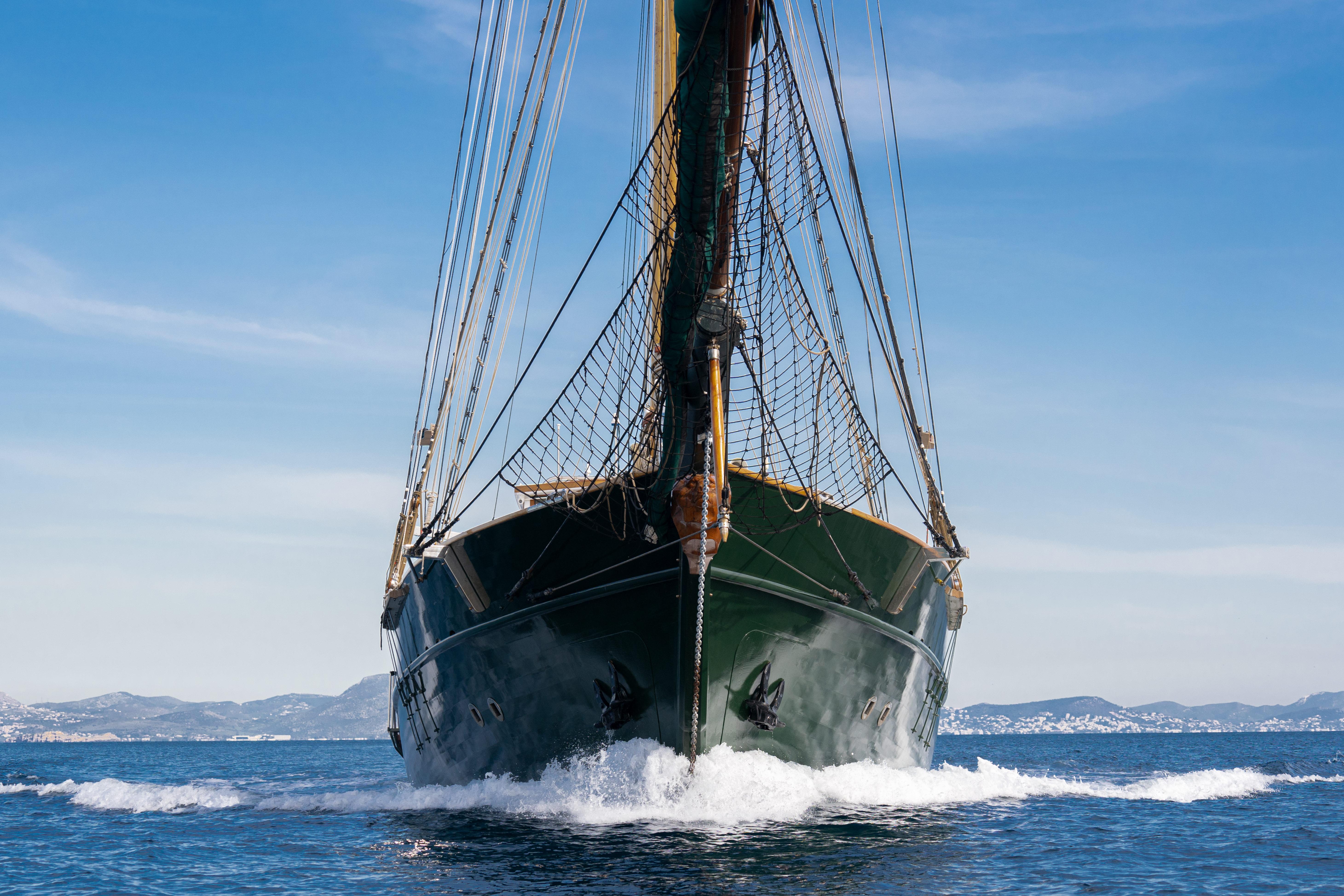 Front view of a custom 2004 sailing ship on the ocean, with clear blue skies.