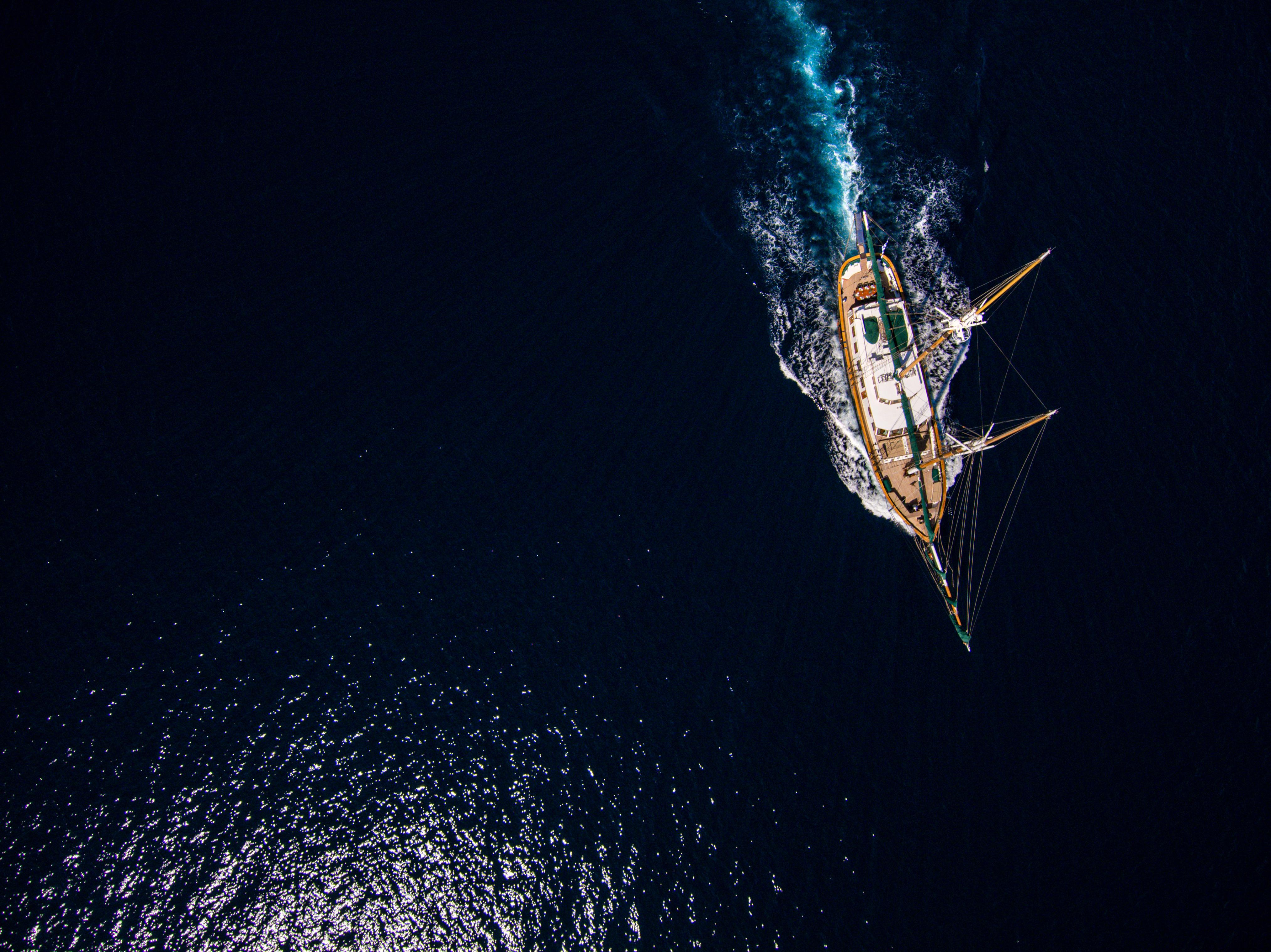 Aerial view of a custom 2004 sailboat navigating through deep blue ocean waters.