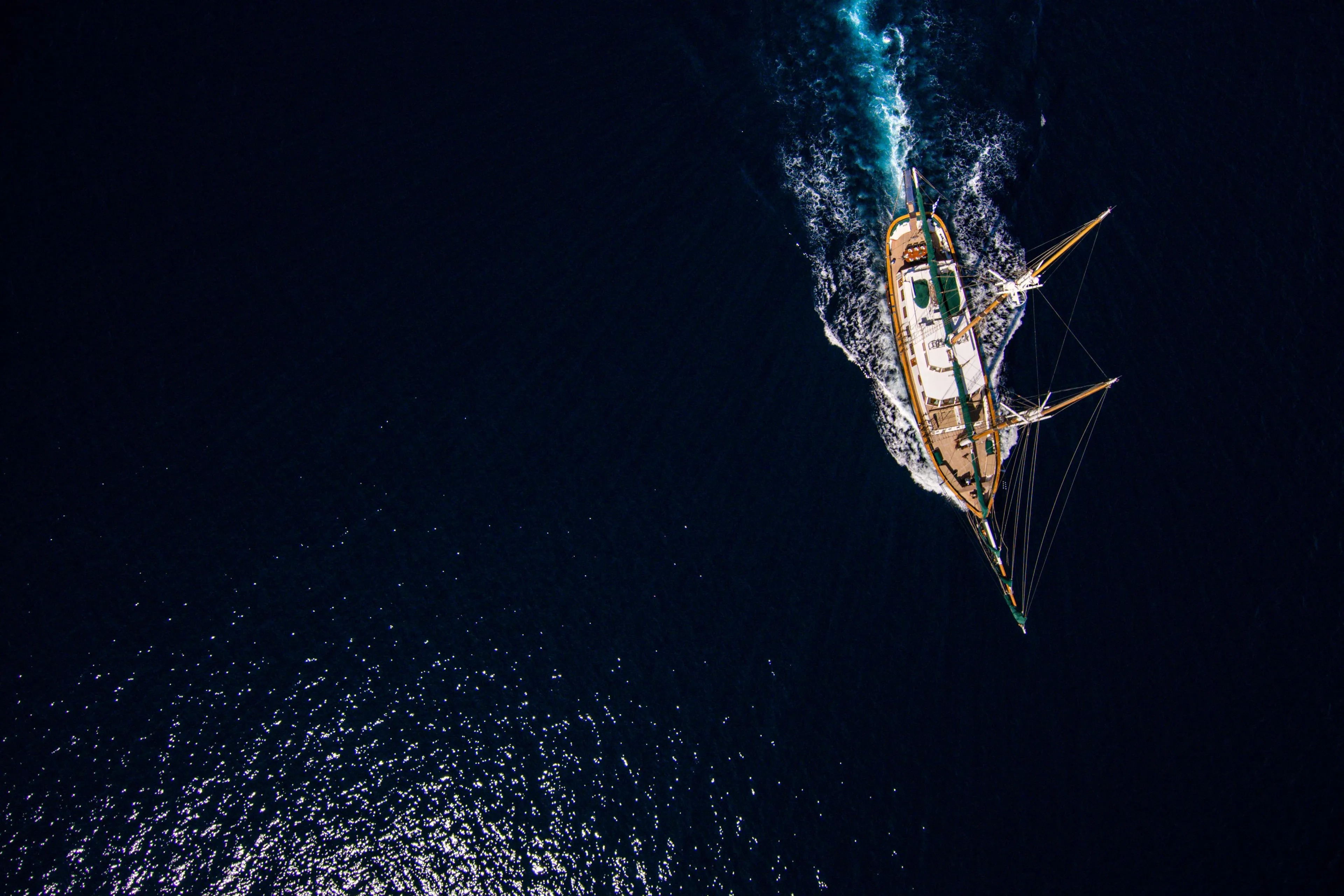 Aerial view of a custom 2004 sailboat navigating through deep blue ocean waters.