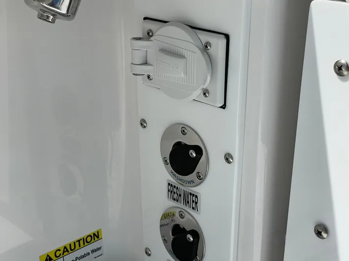 Ice Blue Yacht Photos Pics Freshwater access panel on 2024 Everglades 285CC boat, featuring caution label.