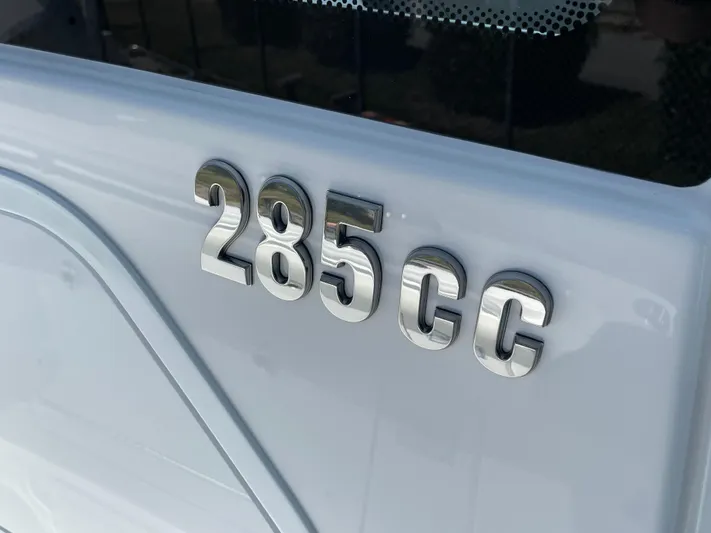 Ice Blue Yacht Photos Pics Close-up of 2024 Everglades 285CC boat model emblem on white surface.