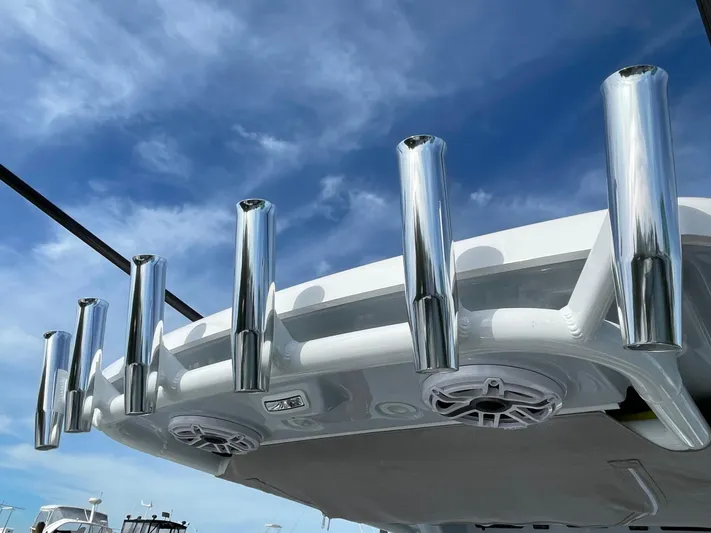 Ice Blue Yacht Photos Pics 2024 Everglades 285CC boat with chrome rod holders against a clear blue sky.