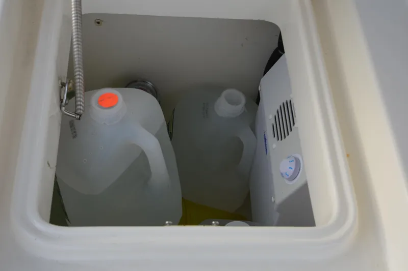 Piper Yacht Photos Pics Storage compartment on a 2007 Jeanneau Prestige 46 yacht with water jugs and equipment.