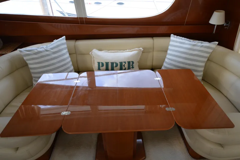 Piper Yacht Photos Pics Luxurious interior of 2007 Jeanneau Prestige 46 yacht with elegant wooden table and plush seating.