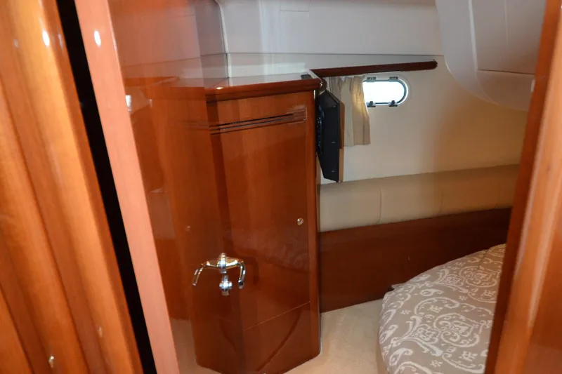 Piper Yacht Photos Pics Interior cabin of 2007 Jeanneau Prestige 46 yacht with wooden cabinetry and porthole.