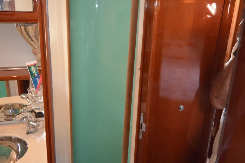 Piper Yacht Photos Pics Interior of 2007 Jeanneau Prestige 46 yacht bathroom with sink and wooden finishes.