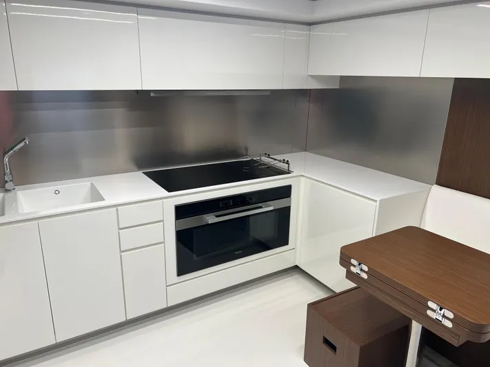 Hk 007 Yacht Photos Pics Modern kitchen interior on 2024 Riva 102' Corsaro Super yacht, featuring sleek white cabinetry.