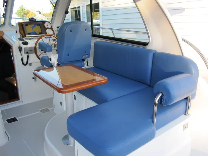 Two 0 Seven Yacht Photos Pics 2011 Back Cove 30 interior with blue seating and wooden table.