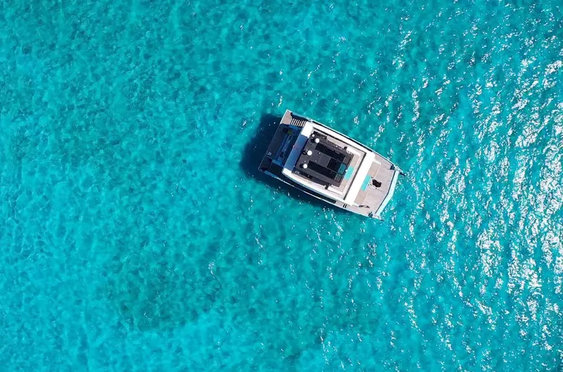 Rockstar 2.0 Yacht Photos Pics Aerial view of 2018 Sunreef 68 Supreme yacht on clear turquoise water.