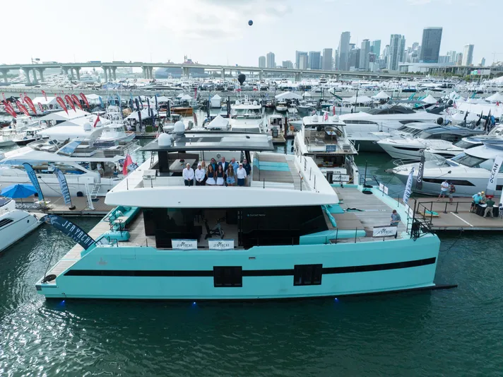 Rockstar 2.0 Yacht Photos Pics 2018 Sunreef 68 Supreme yacht docked at marina, city skyline in background.