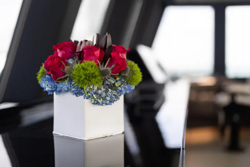 Rockstar 2.0 Yacht Photos Pics Floral arrangement on Sunreef 68 Supreme yacht, 2018 model, featuring vibrant red and green flowers.