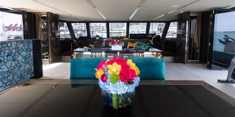Rockstar 2.0 Yacht Photos Pics Luxurious interior of 2018 Sunreef 68 Supreme yacht with elegant decor and vibrant floral arrangement.