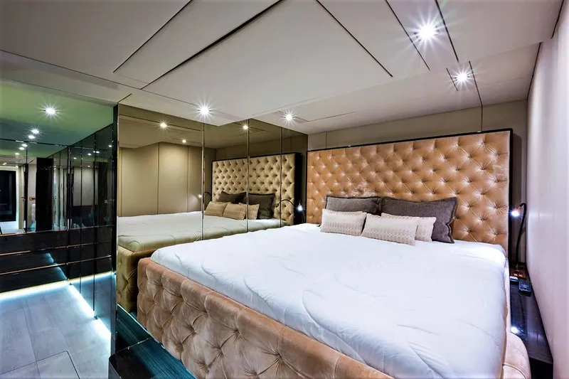 Rockstar 2.0 Yacht Photos Pics Luxurious bedroom interior on 2018 Sunreef 68 Supreme yacht with plush bedding and mirrored walls.