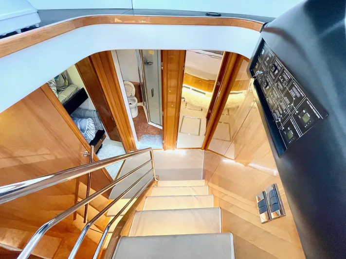 Ellyn Yacht Photos Pics Interior staircase of 2010 Sunseeker Manhattan 70 yacht, featuring sleek wood paneling and modern design.