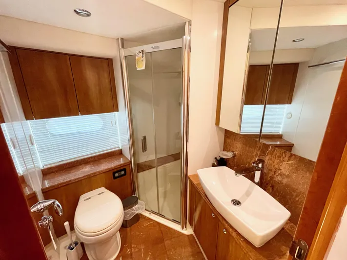 Ellyn Yacht Photos Pics Luxurious bathroom in 2010 Sunseeker Manhattan 70 yacht with modern fixtures and wood accents.